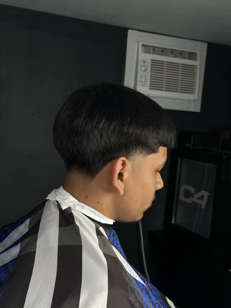 Smooth rounded haircut with neatly tapered sides and a crisp edge.