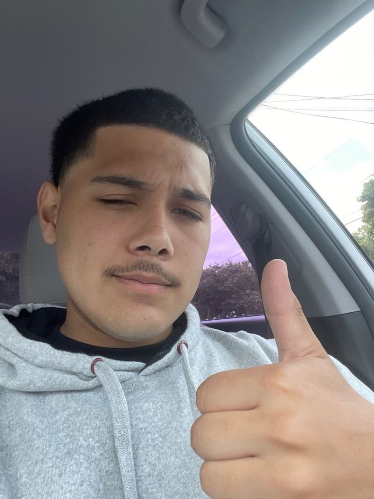 Client showing a short haircut and clean hairline with a thumbs-up.